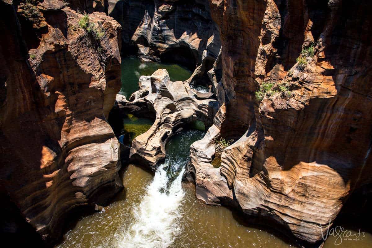looking down into Burke's Luck Pot Holes with water flowing through the intricately carved rock formations. This is a do not miss on your panorama route itinerary.