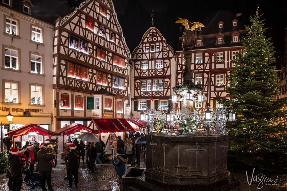 Typical german wooden houses in a medieval town square at night decorated with Christmas lights. 