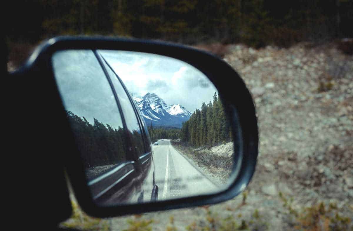 Rocky mountains and Banff National Park in a car side mirror. 
