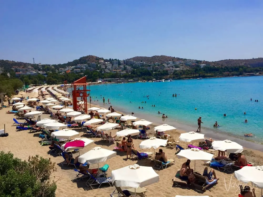A crowded beach of white umbrellas in Athens. Keep Valuables safe at the beach with a locking beach bag.