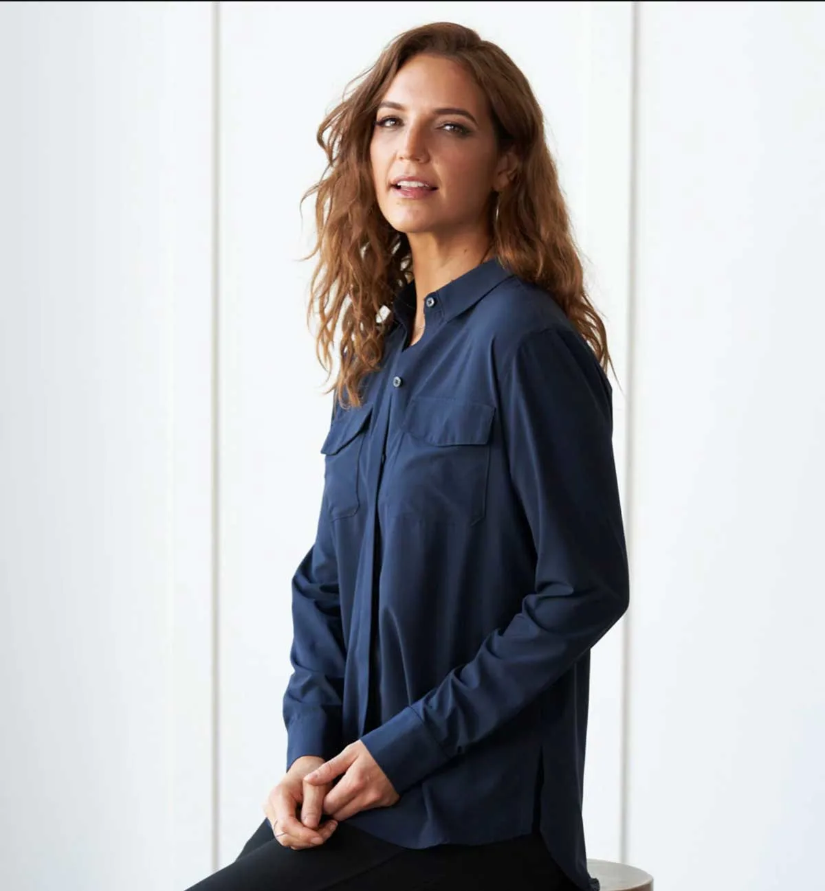 Attractive brown haired woman modelling a navy travel shirt. 