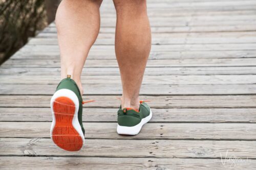 Closeup of mans legs walking along a bardwalk wearing Tropicfeel travel shoes. Possible the best travel shoes we have owned.
