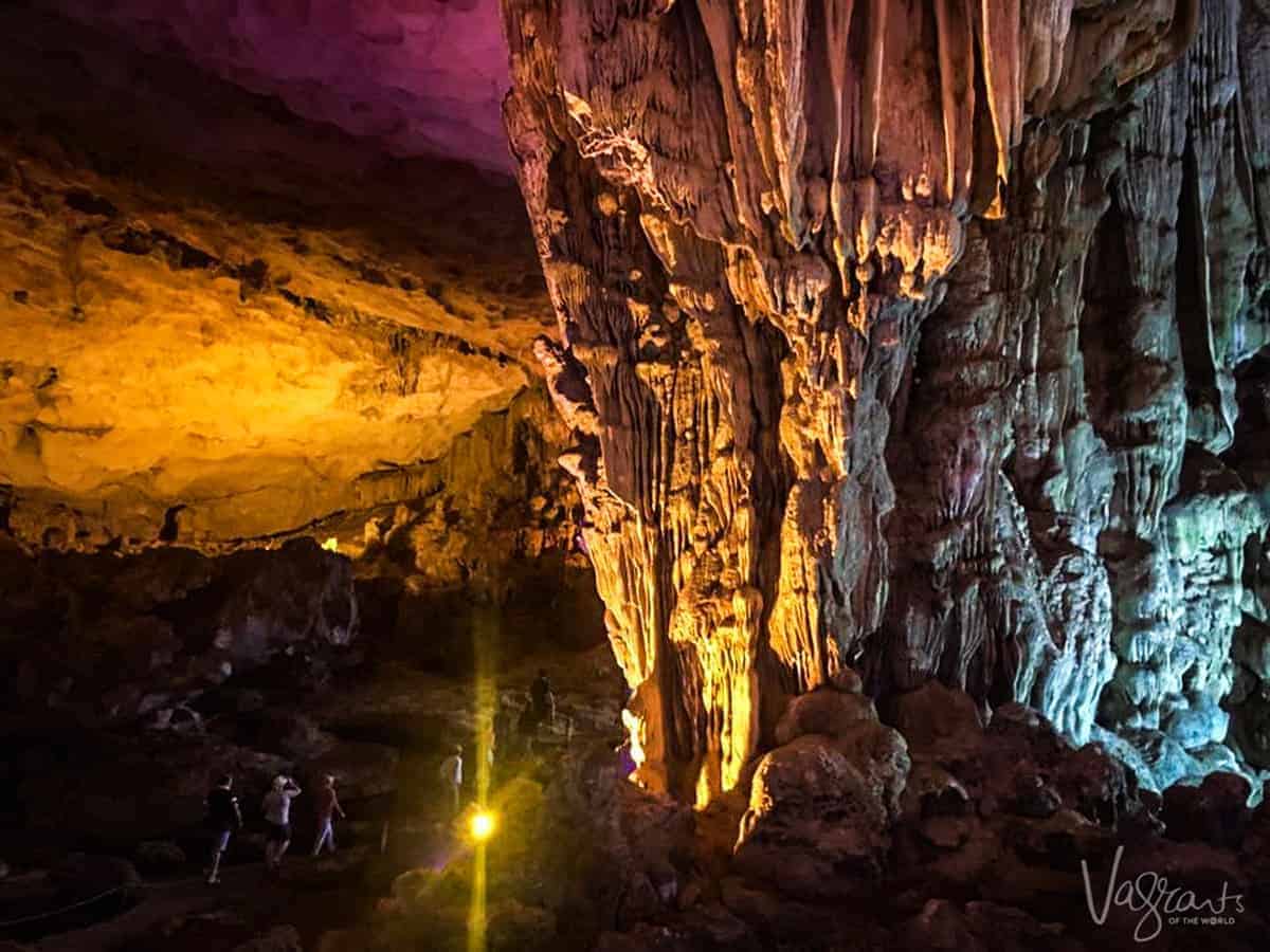 Tourists walk through the strangely lit rock formations in Surprise Cave in Vietnam. 
