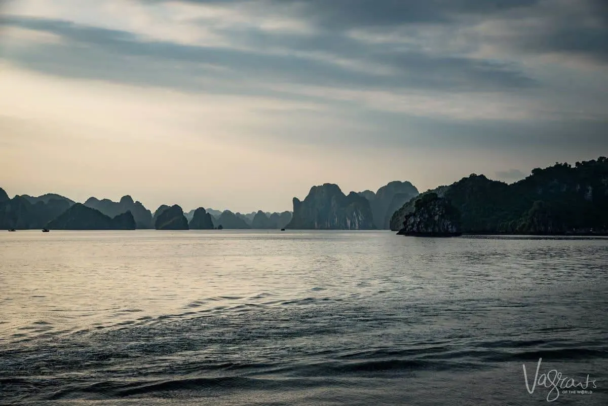 Sunset over Halong Bay creates a silhouette effect of the islands.  