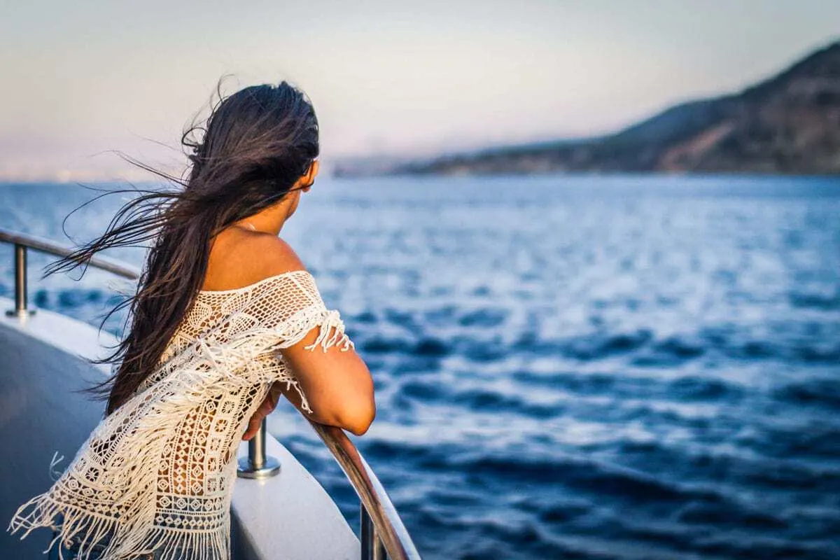 Girl on her own on a ship looking out to see - Last Minute cruise deals are great but how safe are cruises? 