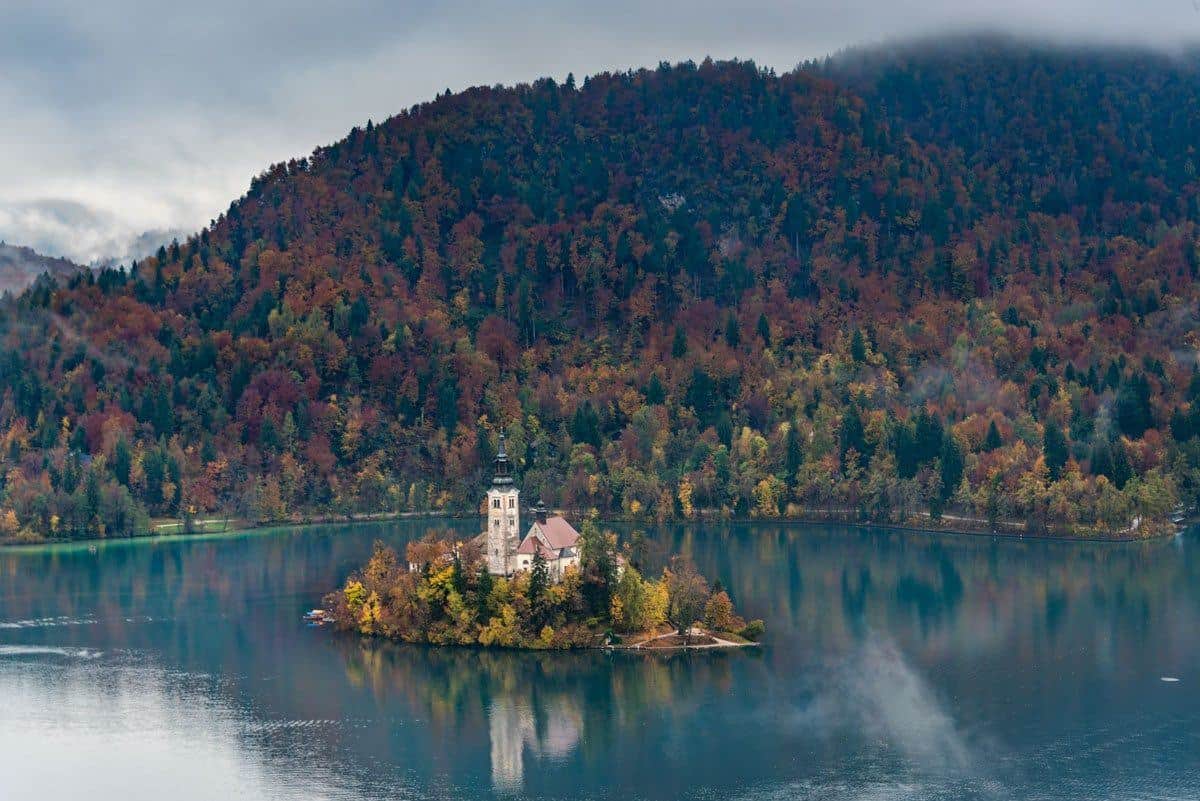 The island with a church on it in the middle of Lake Bled in Autumn