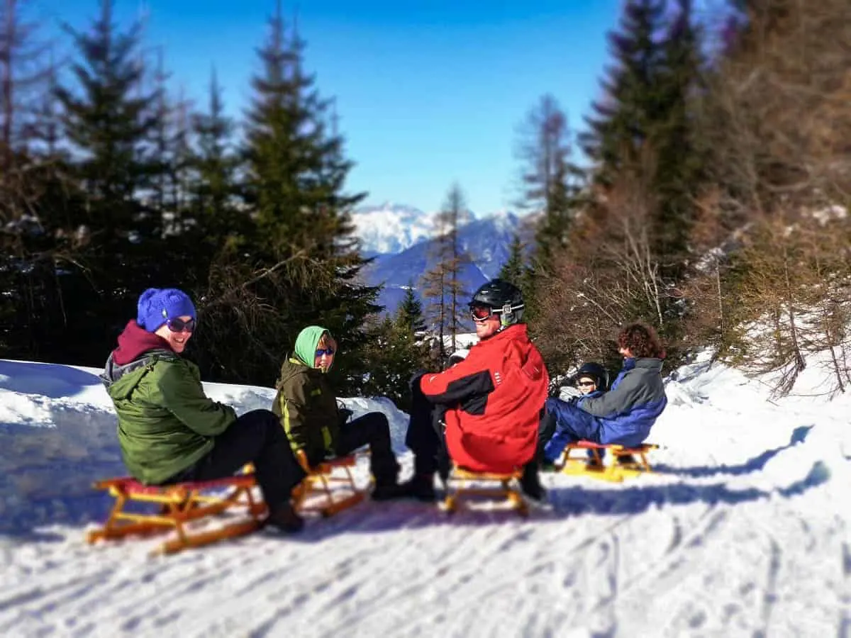 Family tobogganing in the snow in Tyrol Austria