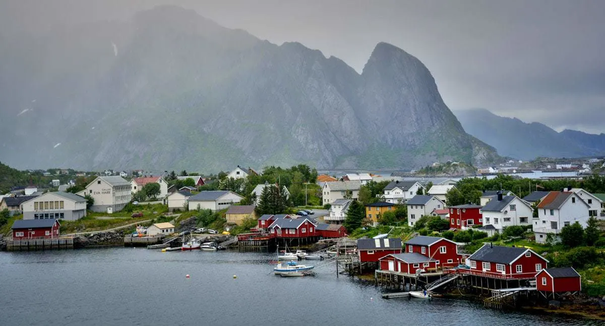 Red buildings with mountains in the background on Lofoten Islands Norway - Snowshoeing in Norway is a great activity in winter in Europe