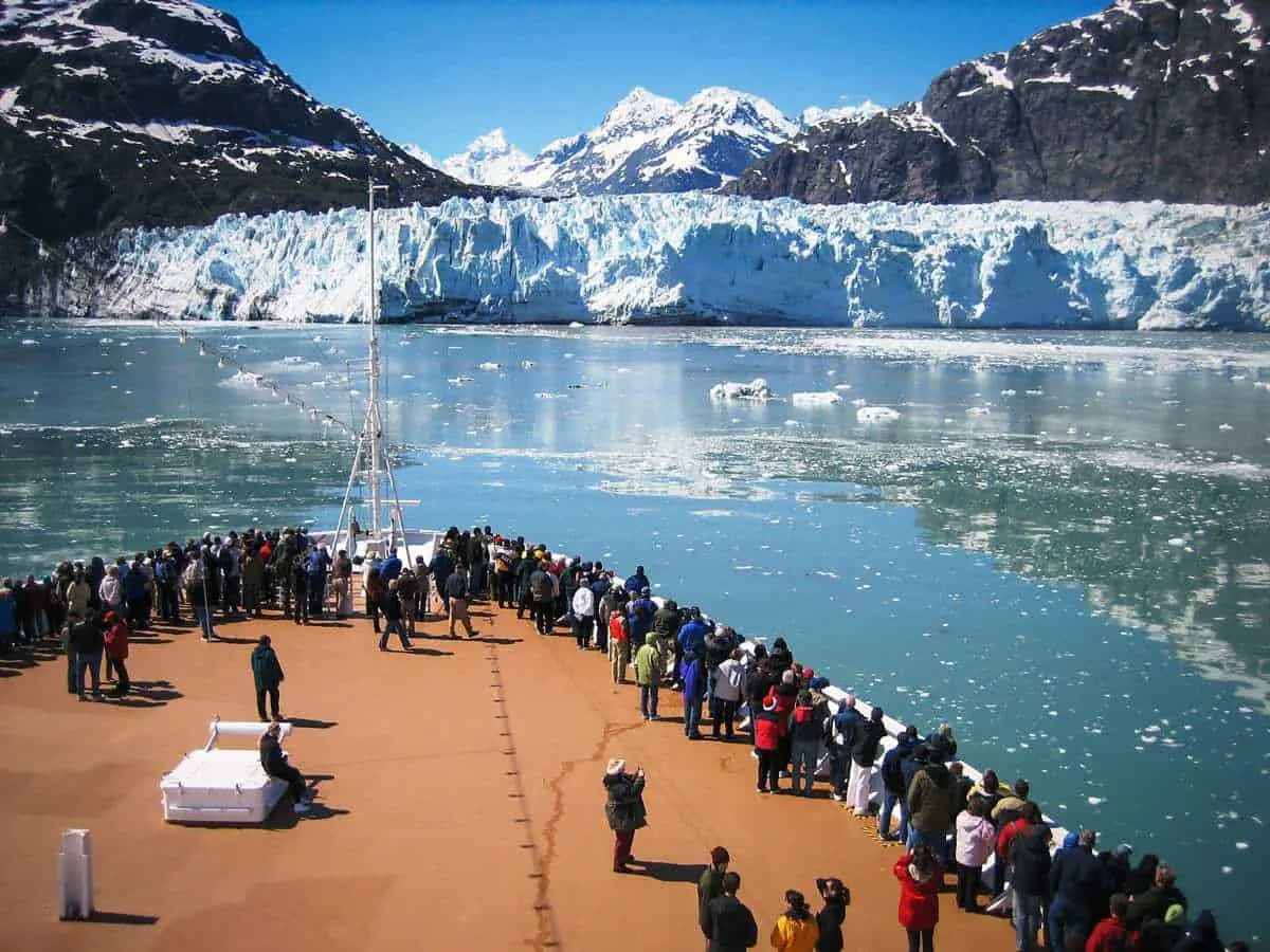 Tourists on the bow of a ship looking at Alaskan glaciers. 