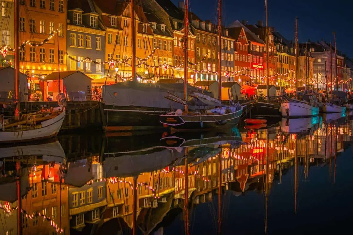 Copenhagen waterfront at Christmas time with yachts decorated in lights. 