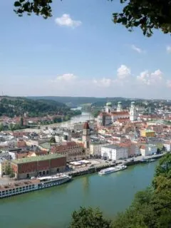 An arial view of Passau showing the river and city in the backdrop on a beautiful sunny blue day.