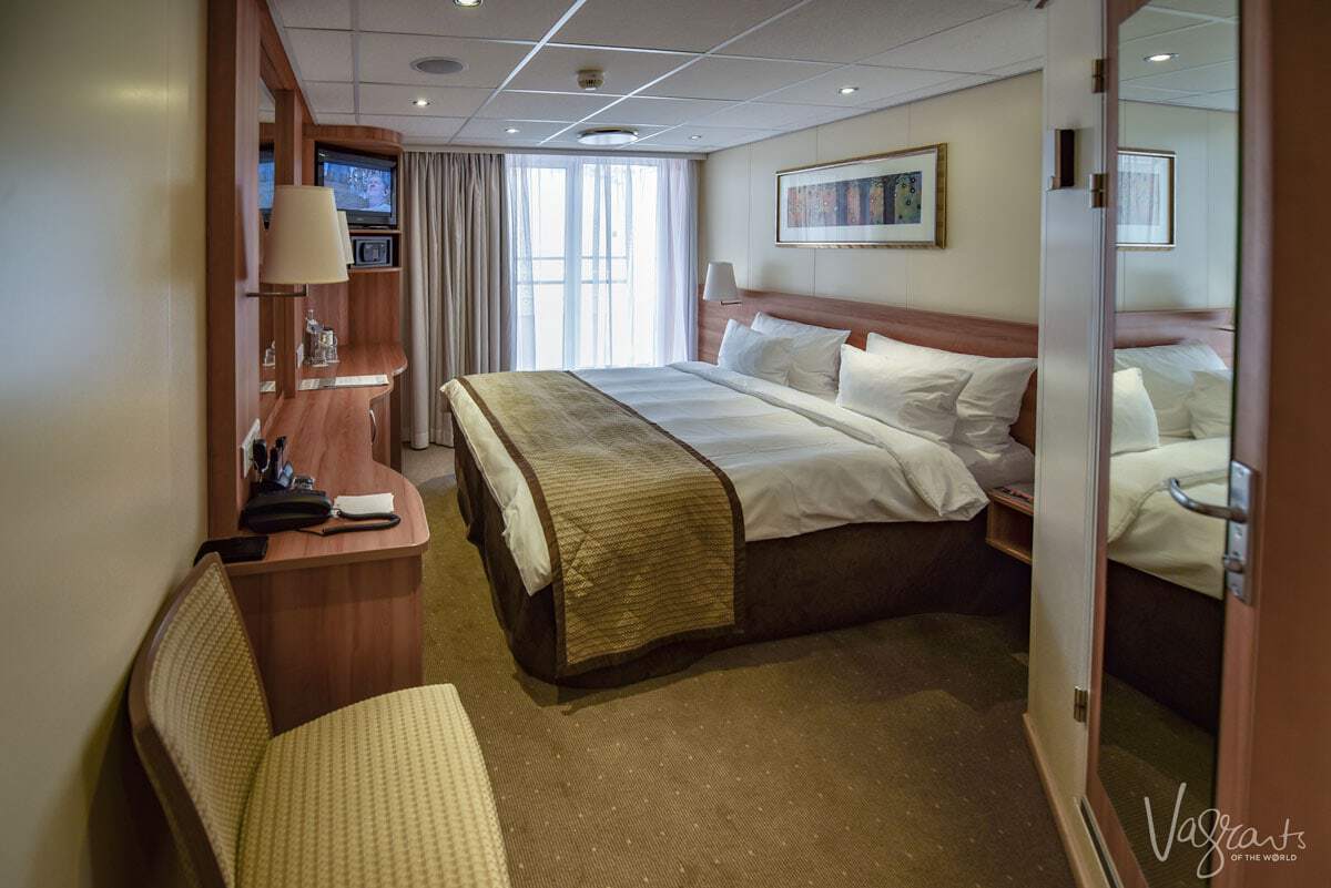 A stateroom on a Viking river cruise showing the bed, window and dresser. 