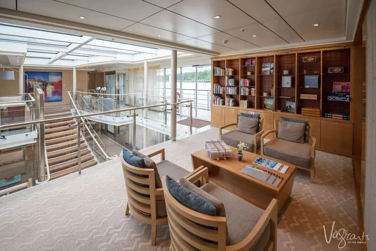 Reading and games area on a viking river cruise with shelves of books and a view of the ships atrium in the background. How should you dress for a viking cruise. Smart casual is the answer, remember you are on holiday and want to look good and be comfortable.