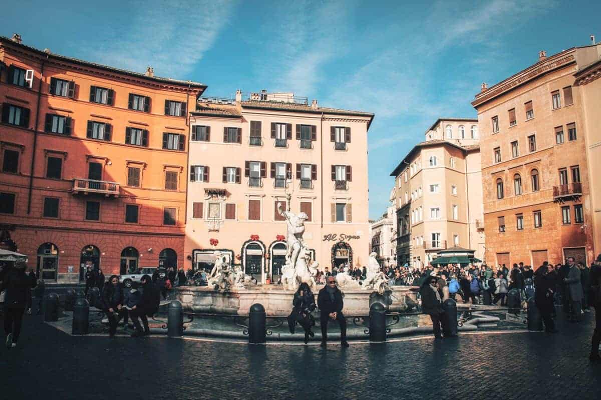 People in front of the Fountain of Neptune in Piazza Navona in Rome. 
