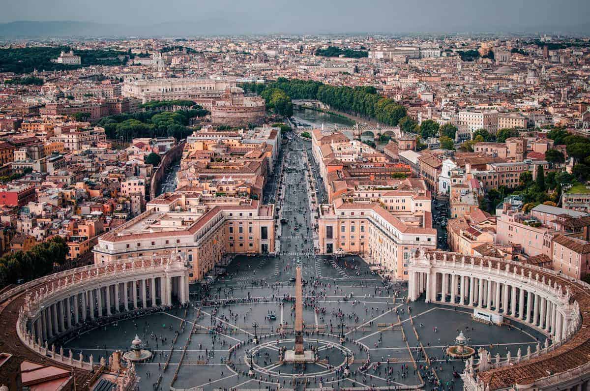 Obelisk, surrounded by semi circular buildings and road leading into the Vatican. 