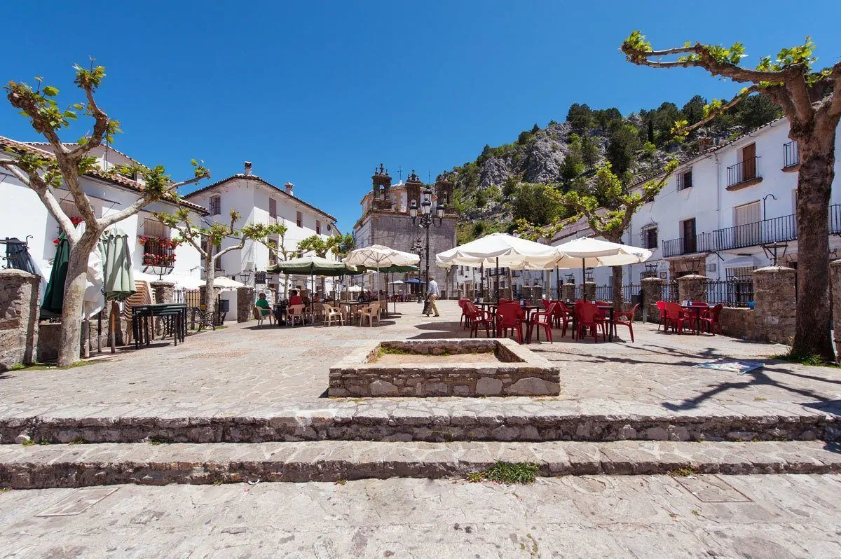 Outdoor restaurants in the village square of Grazalema Spain one of the Pueblos Blancos villages and great place to stop for lunch on your southern spain itinerary