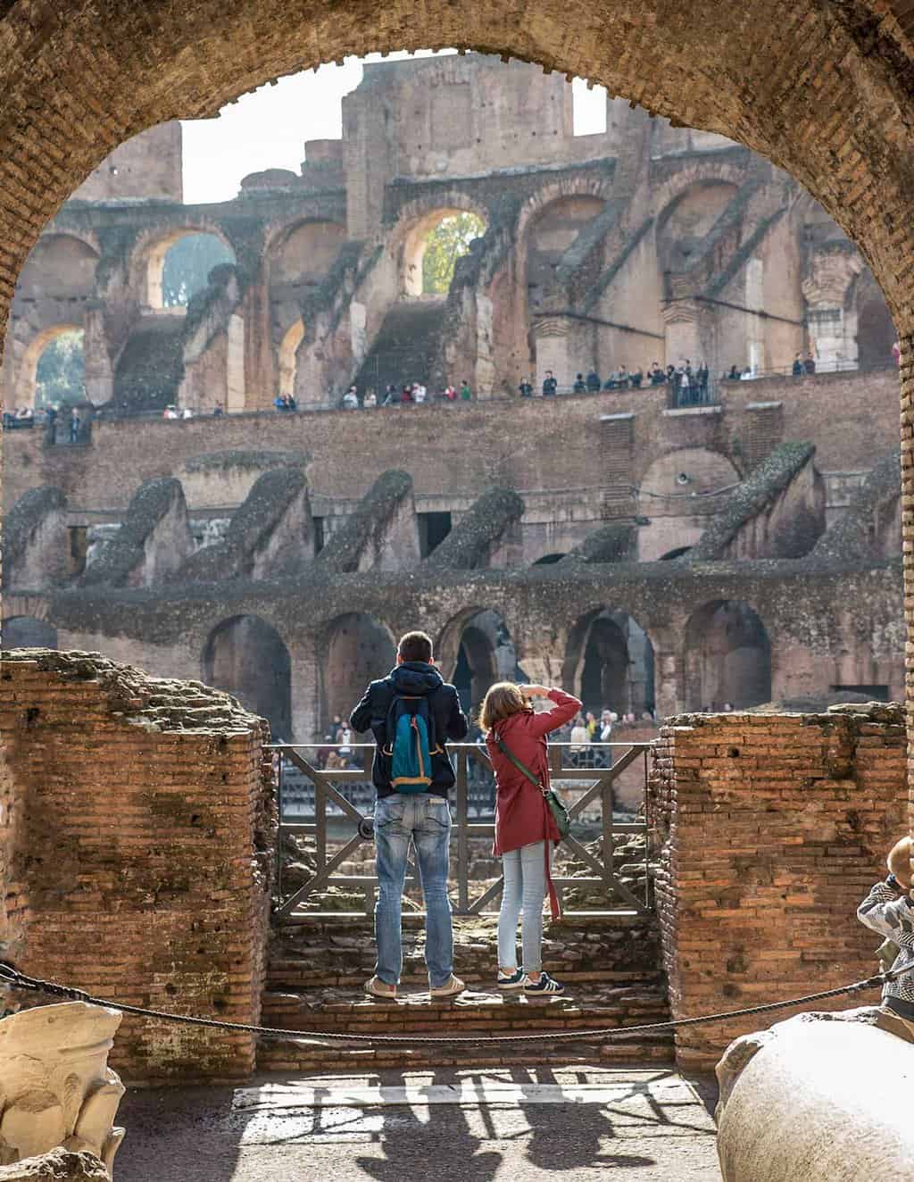 A man and woman tourists looking out over The Colosseum.