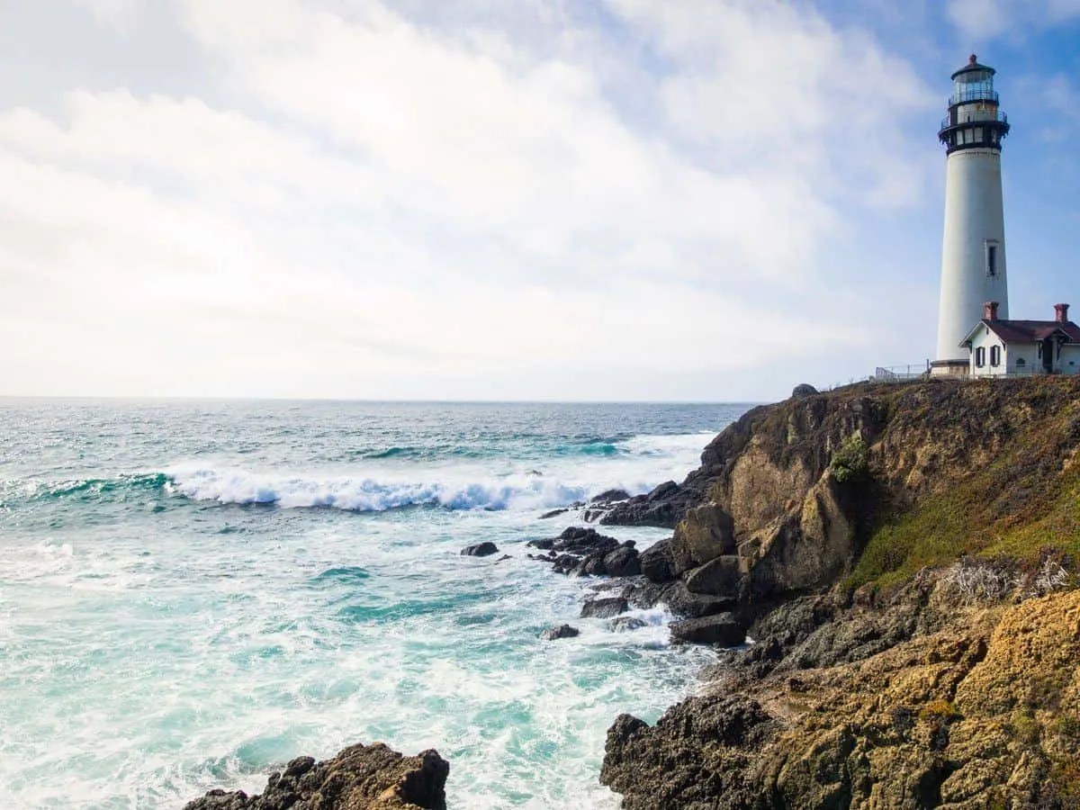 Waves crashing against lighthouse in California.