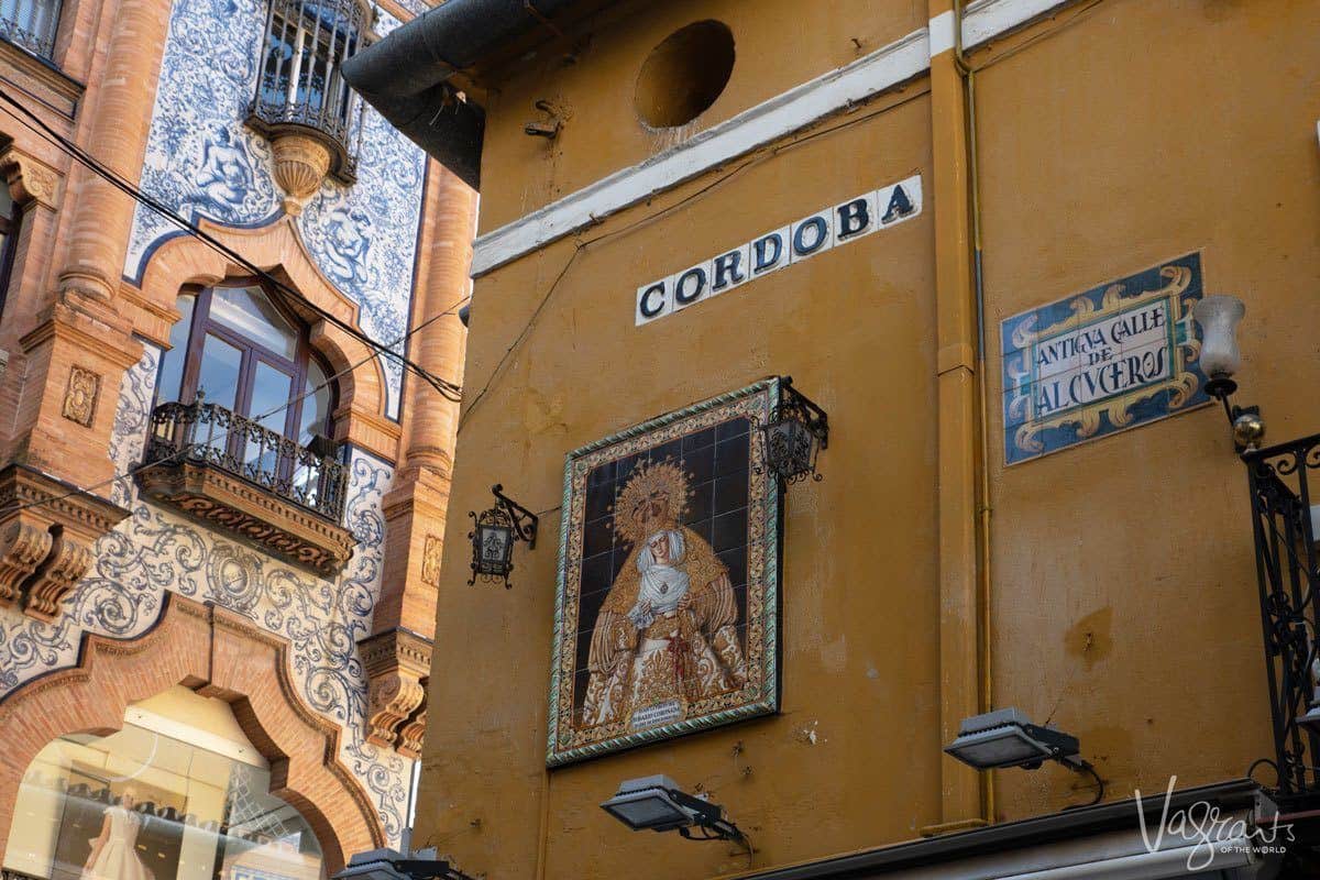 Cordoba rua yellow buildings in Seville with tiled Mary and Jesus. 