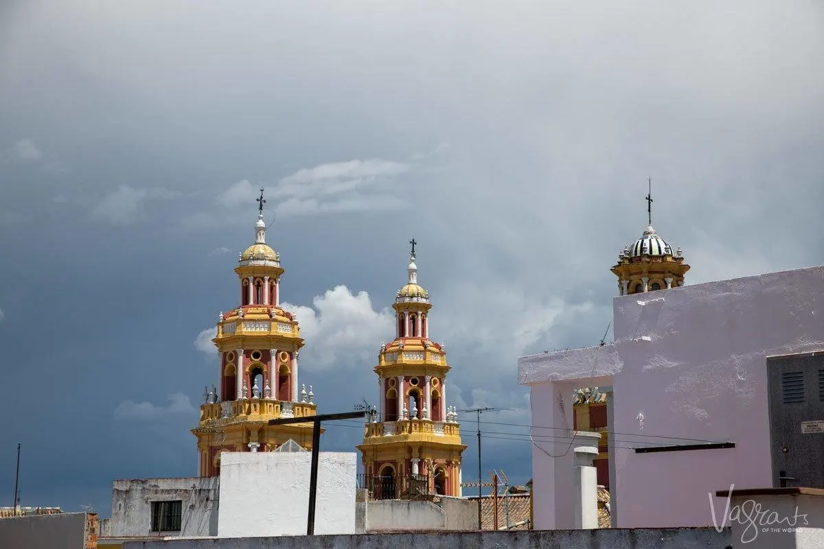 A stormy sky behind the golden bell towers of the cathedral. There is plenty to see and do in Seville on your own.