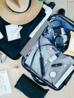 Open suitcase with womens travel gear being packed. Travel safety tips for before you even leave.
