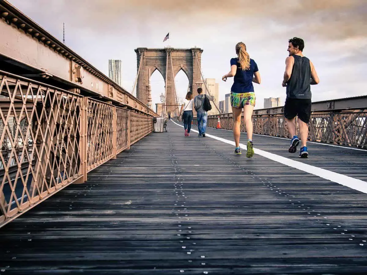 Jogging is a great travel workout routine. A couple joging across a bridge in the city
