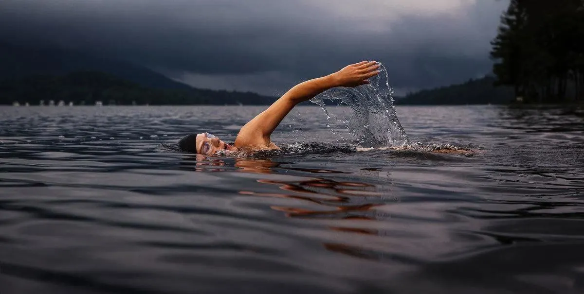 Swimming is an easy travel workout as you don't need a lot of exercise equipment like this man swimming across a lake