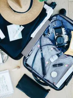 Open suitcase with womens travel gear being packed. Travel safety tips for before you even leave.