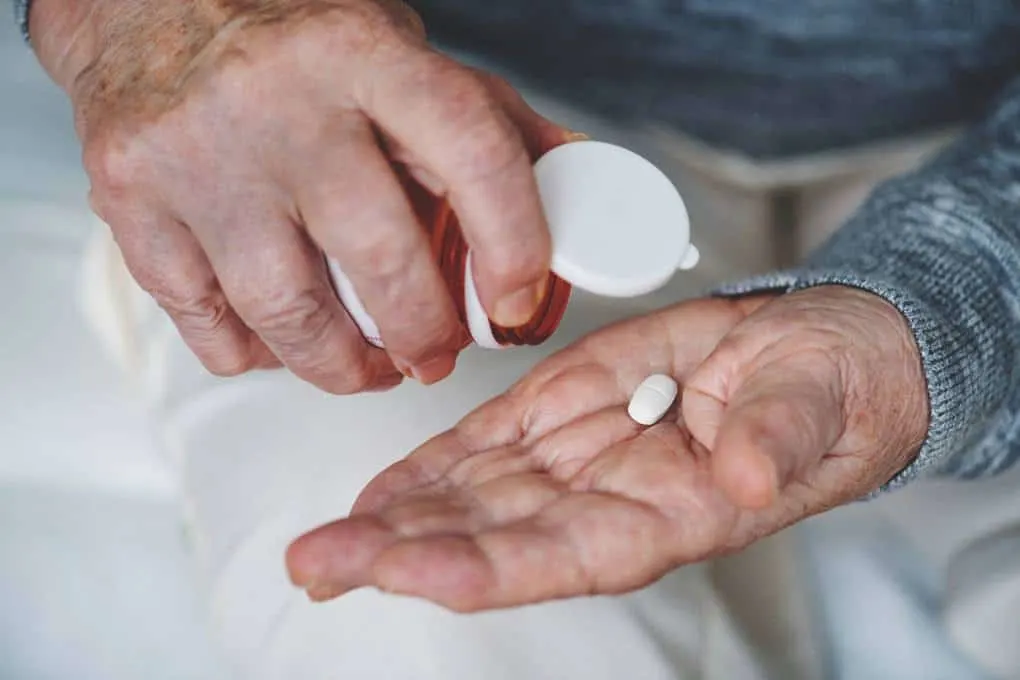 Know the list of banned medications before you travel to any country like this person emptying a pill from a bottle into their hand. 