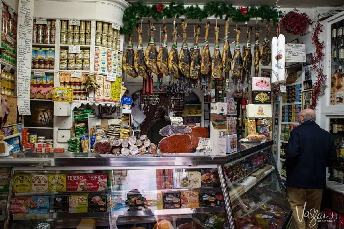Hanging hams and plenty of cheese and olives at Casa Moreno Sevilles oldest grocery store and secret bar. 
