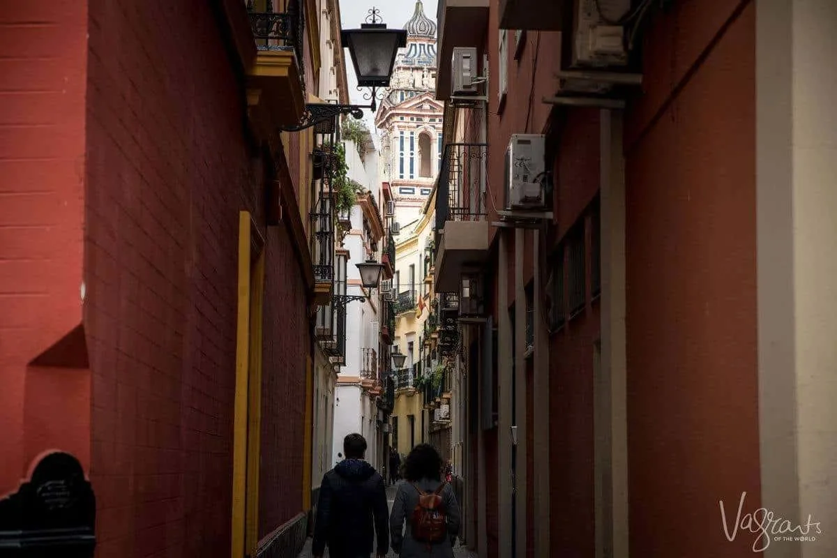 A couple walking down dark narrow streets of Seville. 
