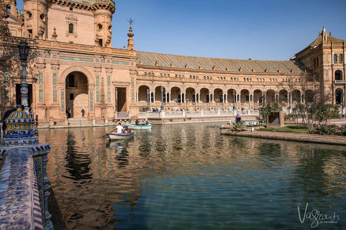 People rowing small boats on the moat outside Plaza de España Seville. 