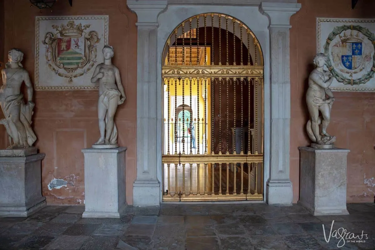 Semi nude female statues beside the golden gate of Casa de Pilatos Seville.