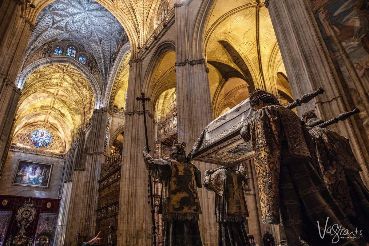 Statue of bishops carrying a coffin inside Seville Cathedral.