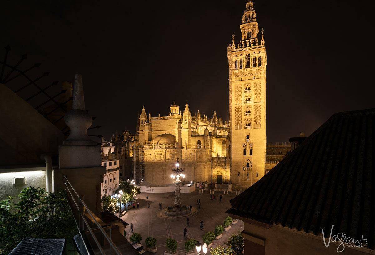 Golden glow of Seville Cathedral lit up at night. 