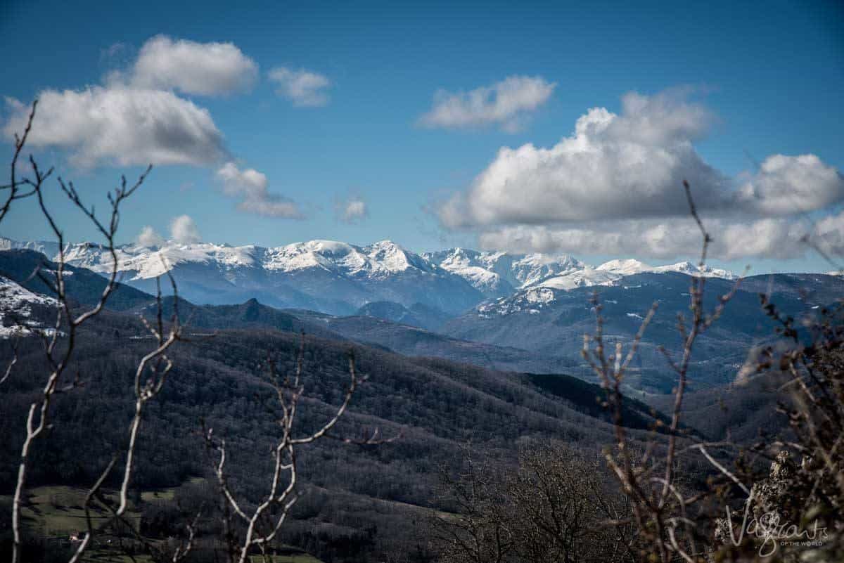 Snowy peaks under a blue and cloudy sky. 