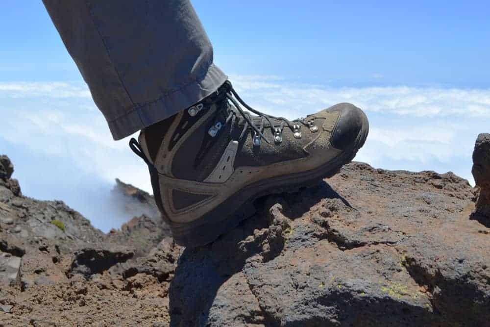 Mans hiking boot on a rock on a mountain. 