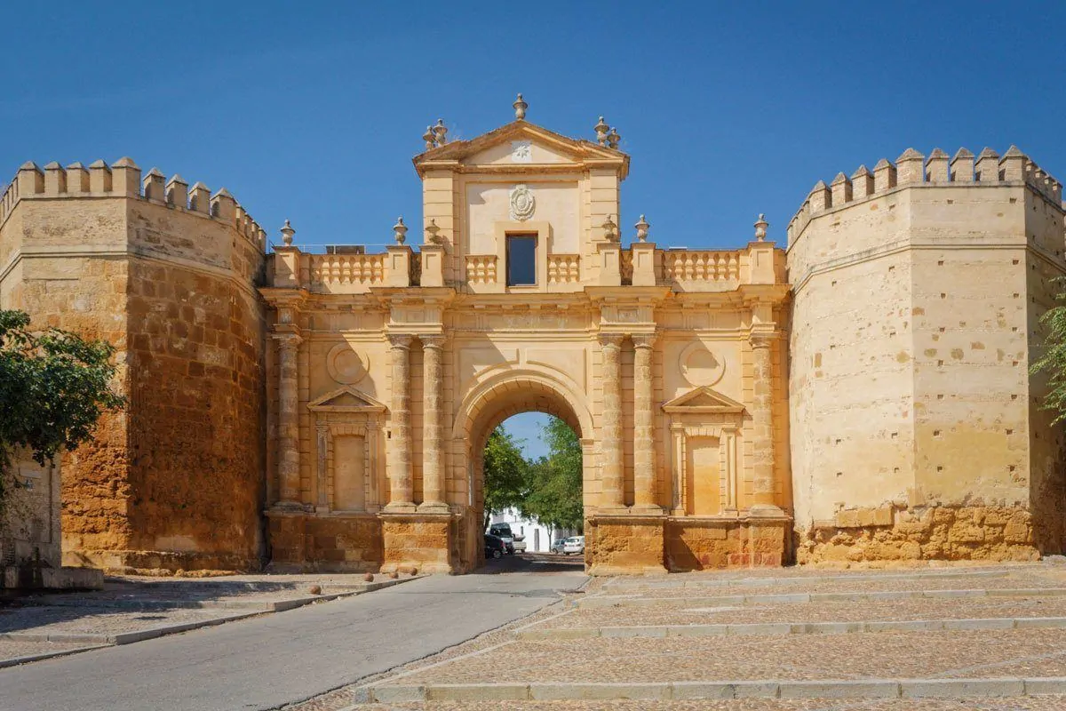 Sandstone pillars and ornate stone entrance to Carmona. Best thing to do in Carmona is to visit this gate. this is one of the best Day trips from Seville to Carmona