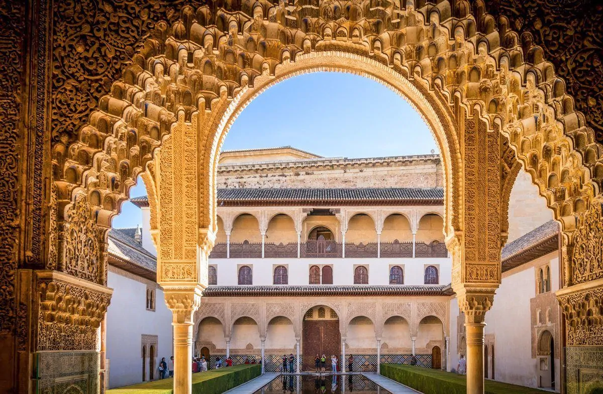 Tourist taking photos of intricate golden arches on the best Day Trip from Seville to Granada