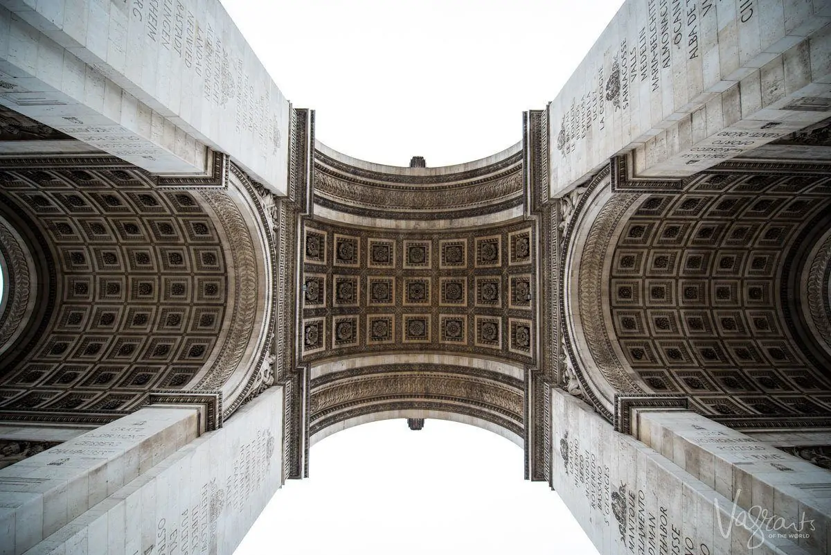 looking up at the arch of the arc de triomphe. angles are one of the best Travel Photography Tips for Getting the Best Landmark Shots