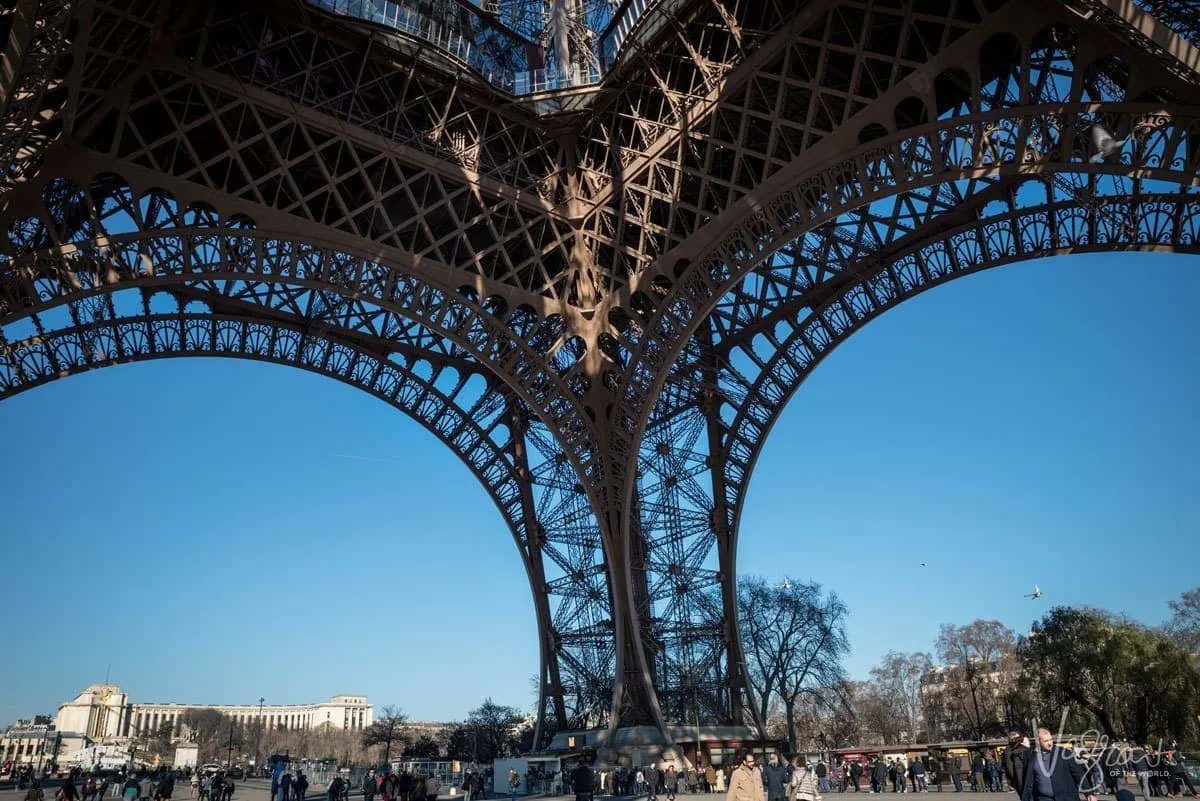 under an arched leg of the eiffel tower. giving thought to composition is one of the best Travel Photography Tips for Getting the Best Landmark Shots