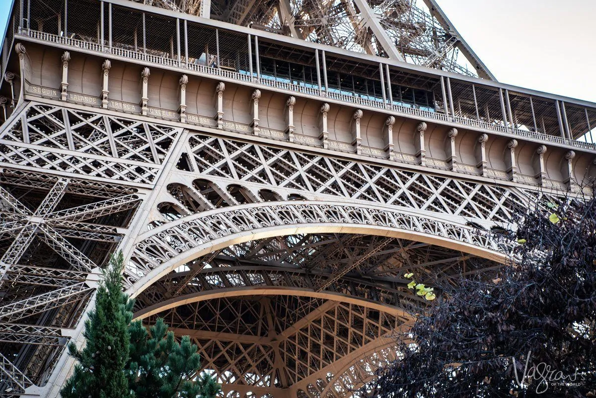looking up from the outside at an arched leg of the eiffel tower. giving thought to composition is one of the best Travel Photography Tips for Getting the Best Landmark Shots