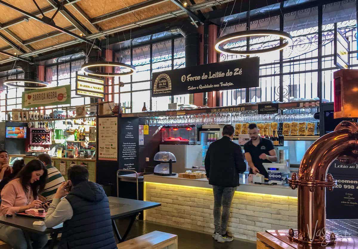 Two people eating and another buying lunch at Mercado Beira-Rio. 