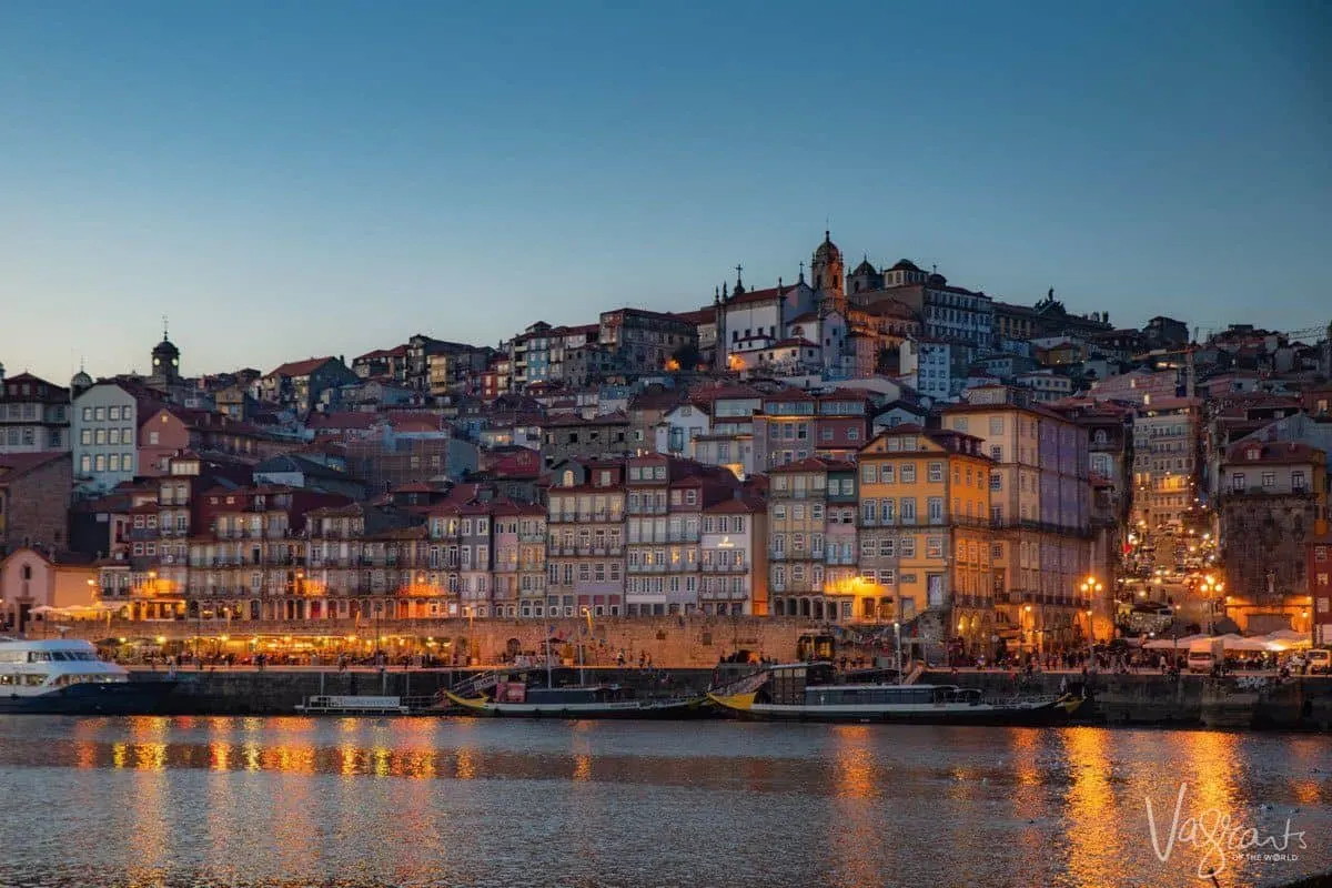 Douro river and lit buildings of the Ribeira neighbourhood in the early evening.
