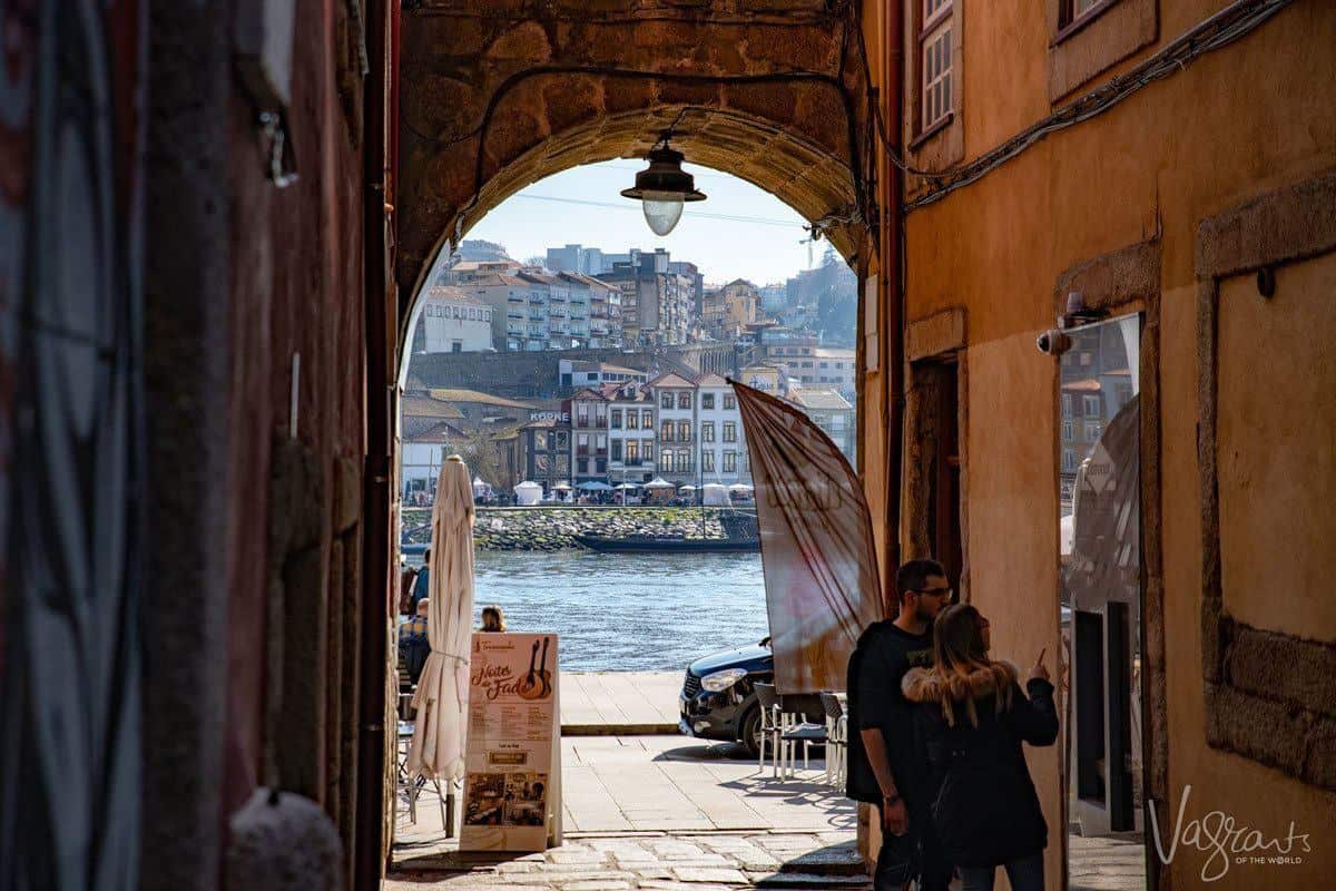 Two tourist window shopping in an alley leading down to the Douro river in the Ribeira neighbourhood. 