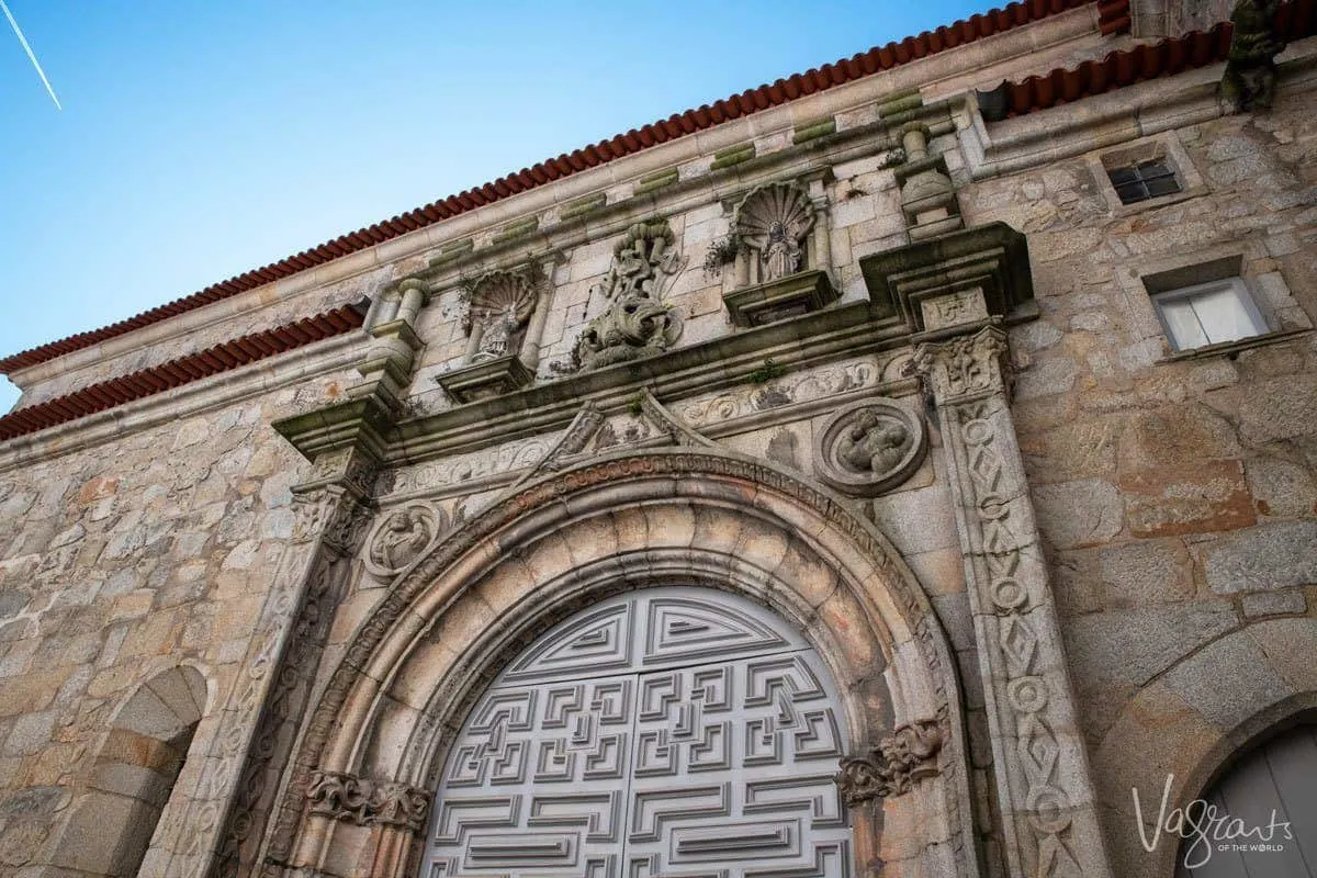 Ornate doors and archway of the sandstone coloured Church of Santa Clara in Porto.