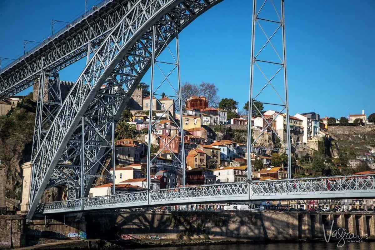 A section of the steel structure of the D. Luis I bridge with houses on the hill in the background. 