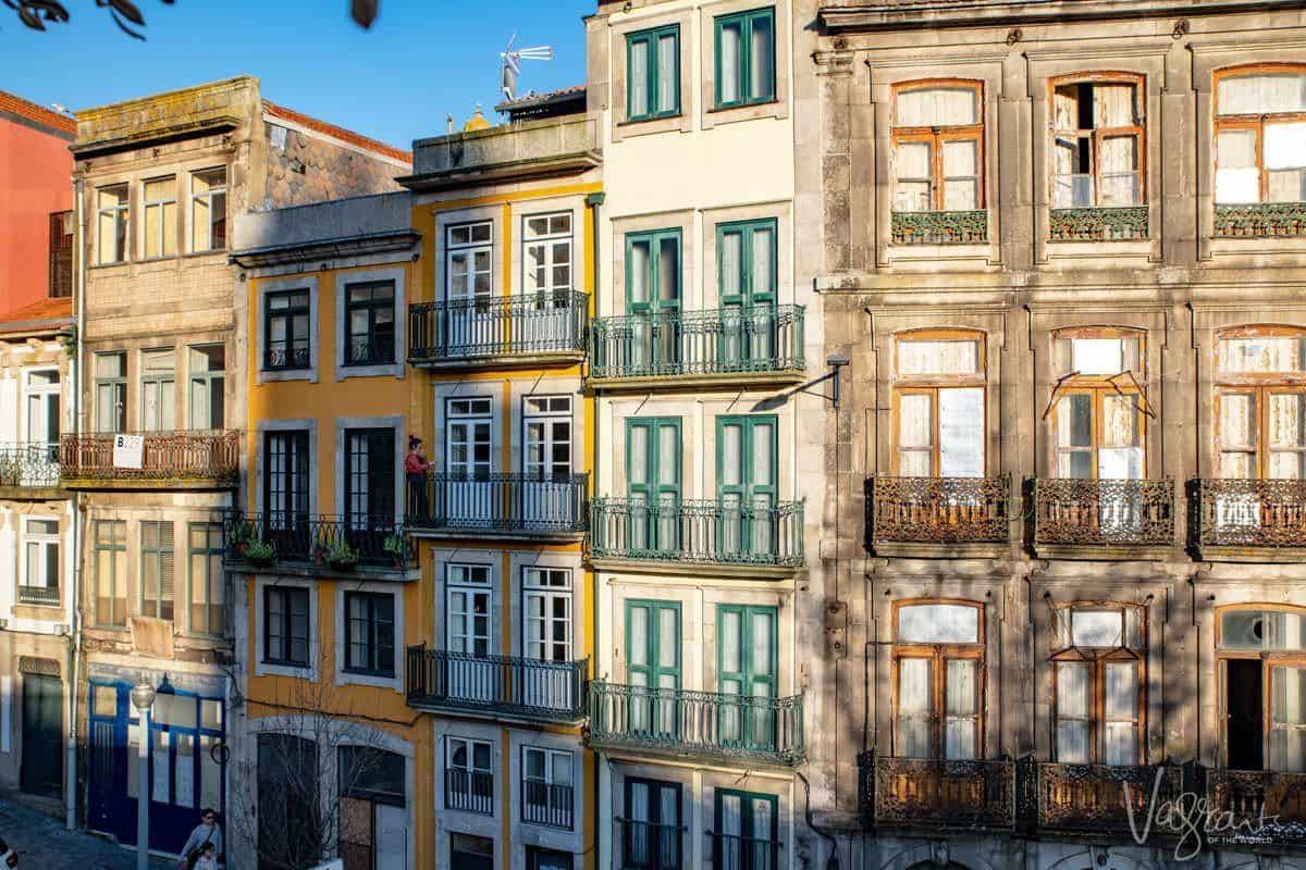 Tall skinny multicoloured buildings with their tiny balconies and brightly painted doors in blues and yellows.