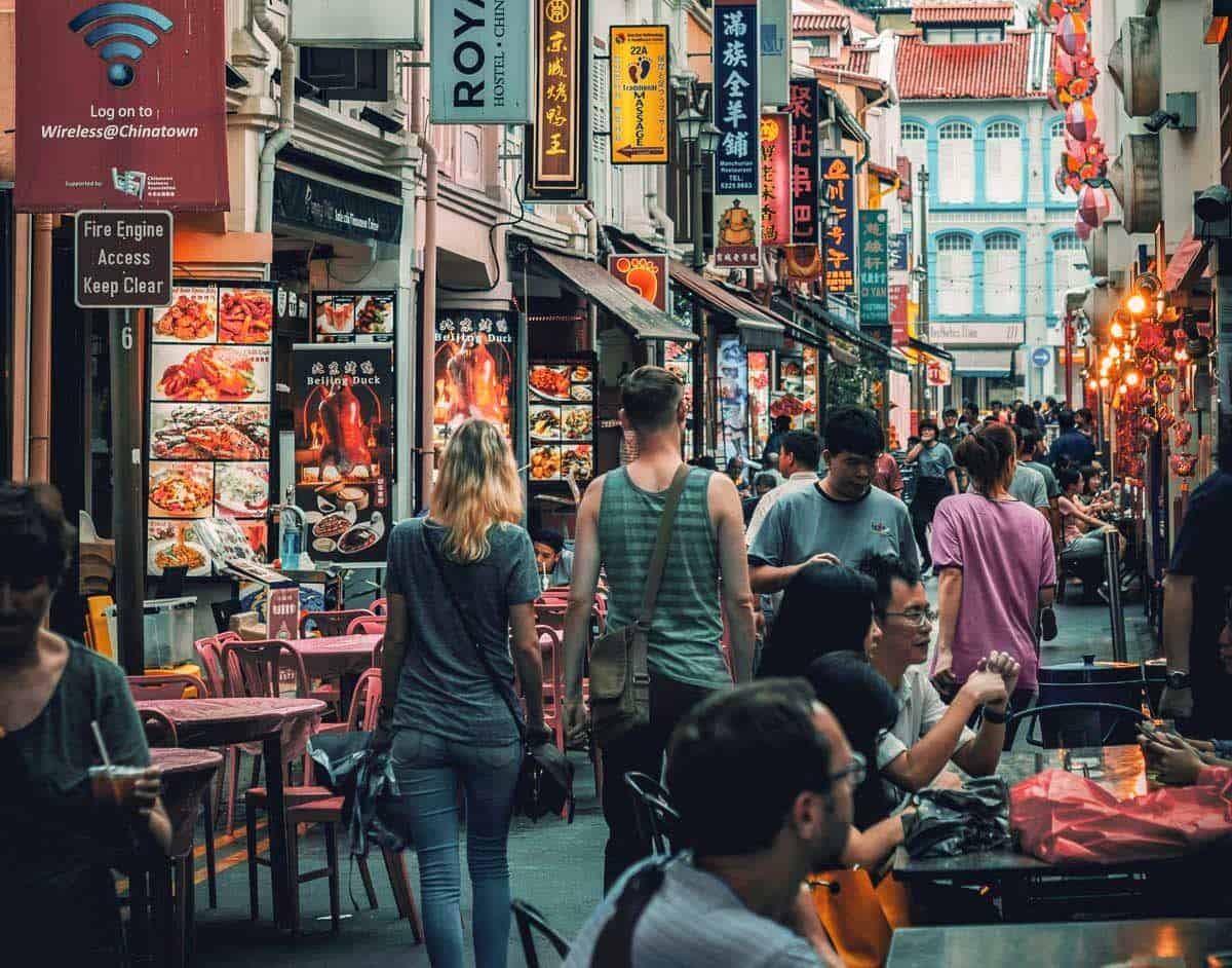 Tourists walking through restaurant alley in Singapore. 