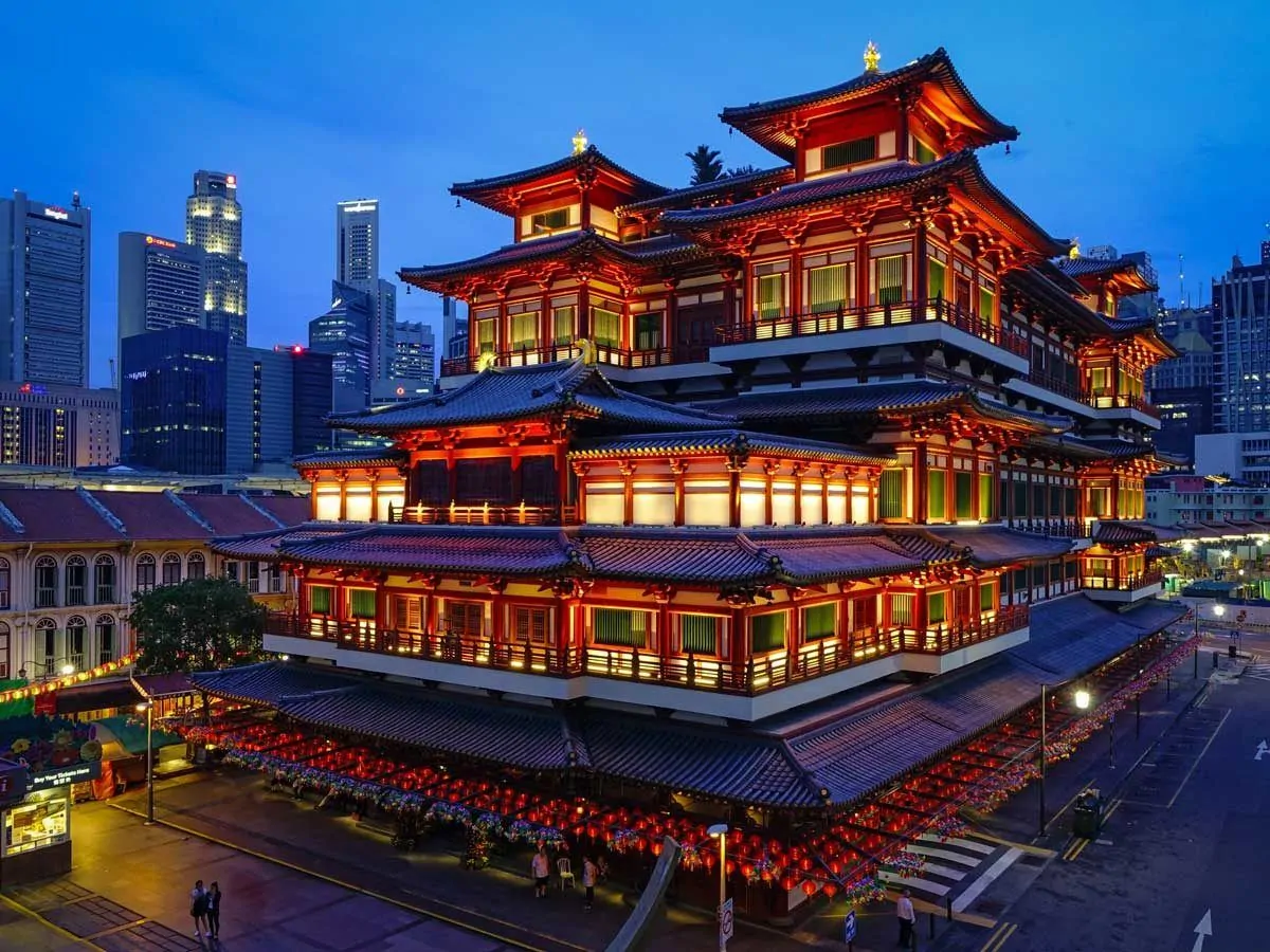 Pagoda lit up at night with red on white lights of this building made of many ornate squares. 